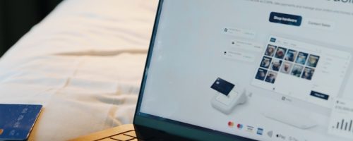 Laptop, phone, and card on a bed.